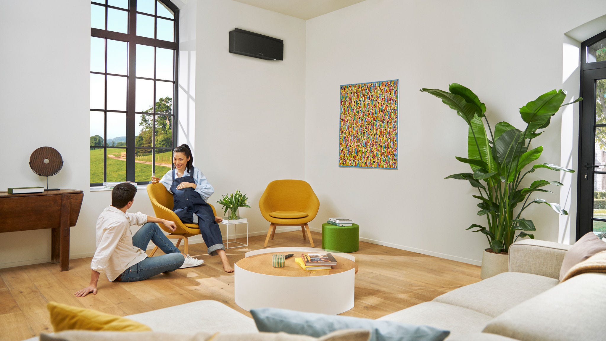 Trudnica i partner ležerno razgovaraju dok žena sedi na stolici