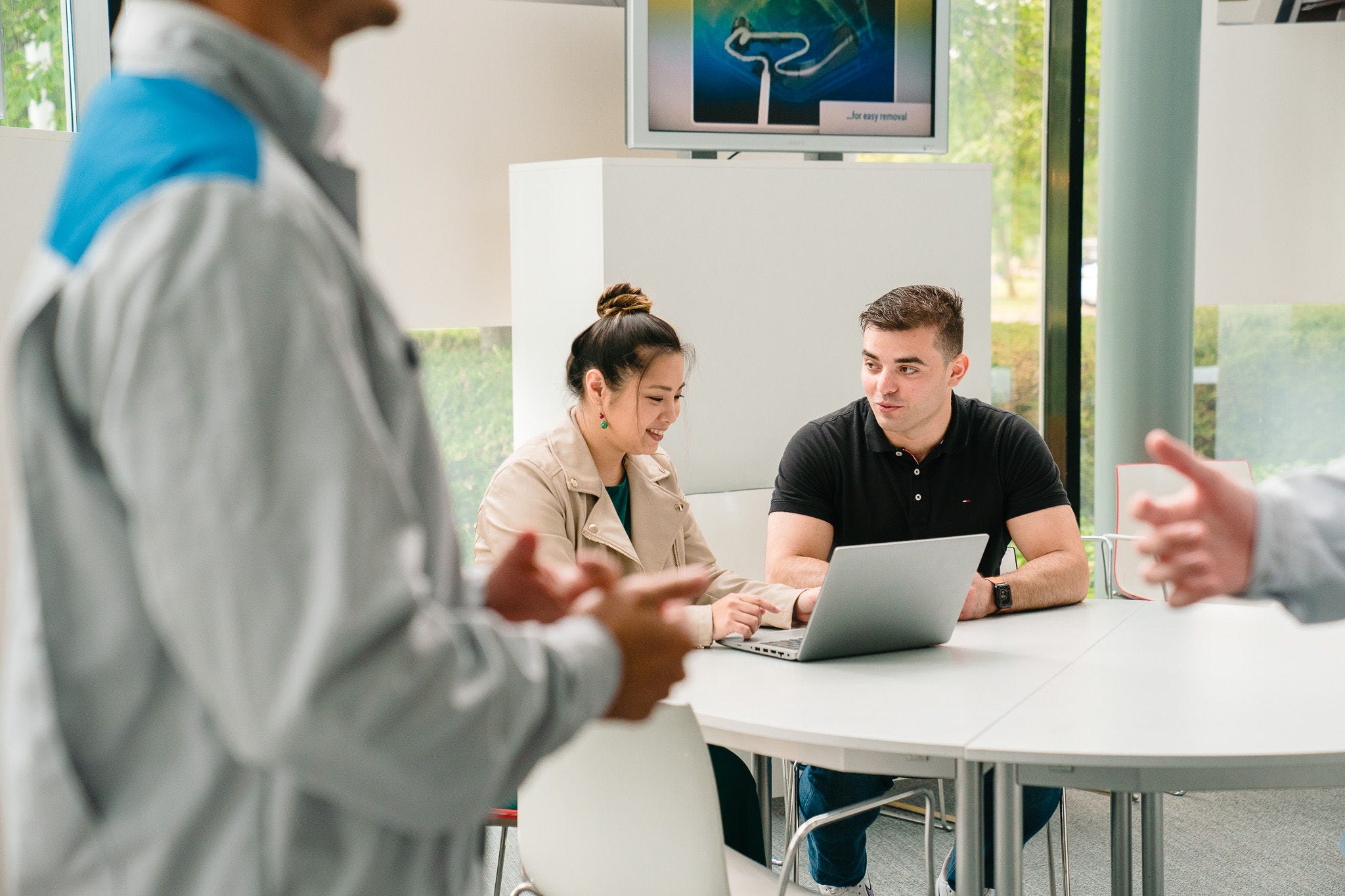 Žena muškarcu objašnjava nešto na laptopu