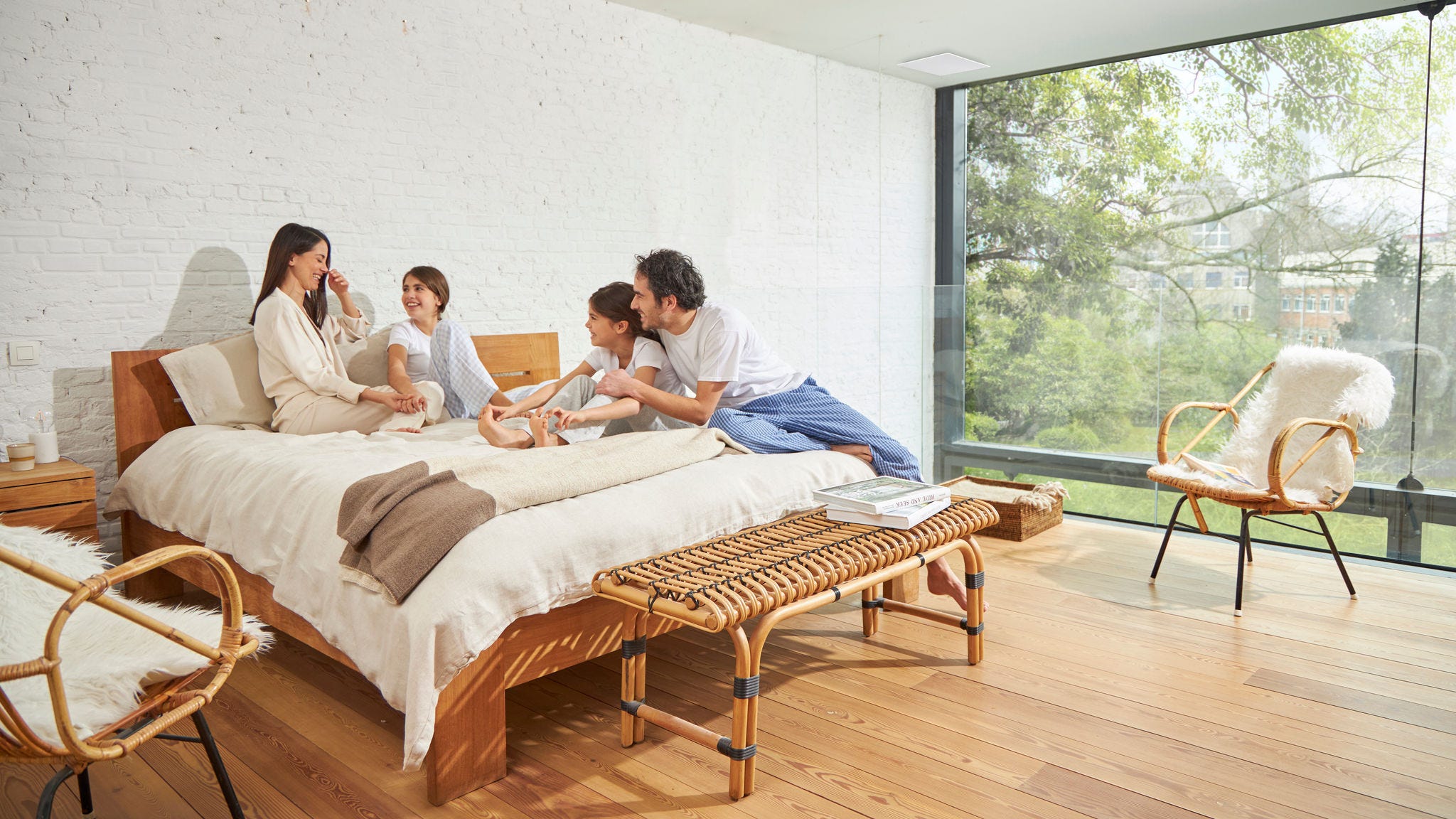 Četvoročlana porodica koja uživa u dobro ventilisanoj spavaćoj sobi