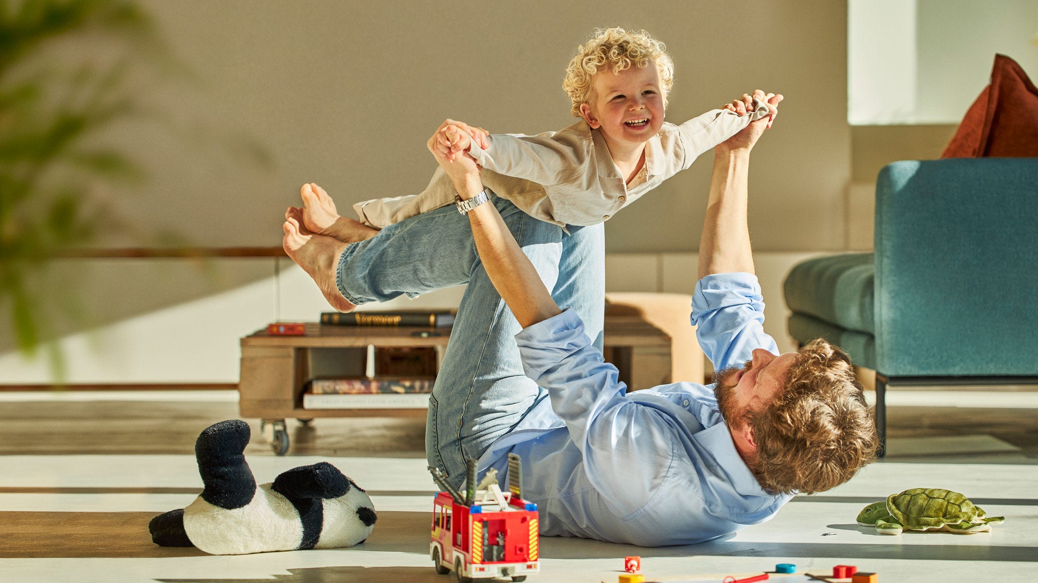 Otac se igra sa svojim detetom na podu