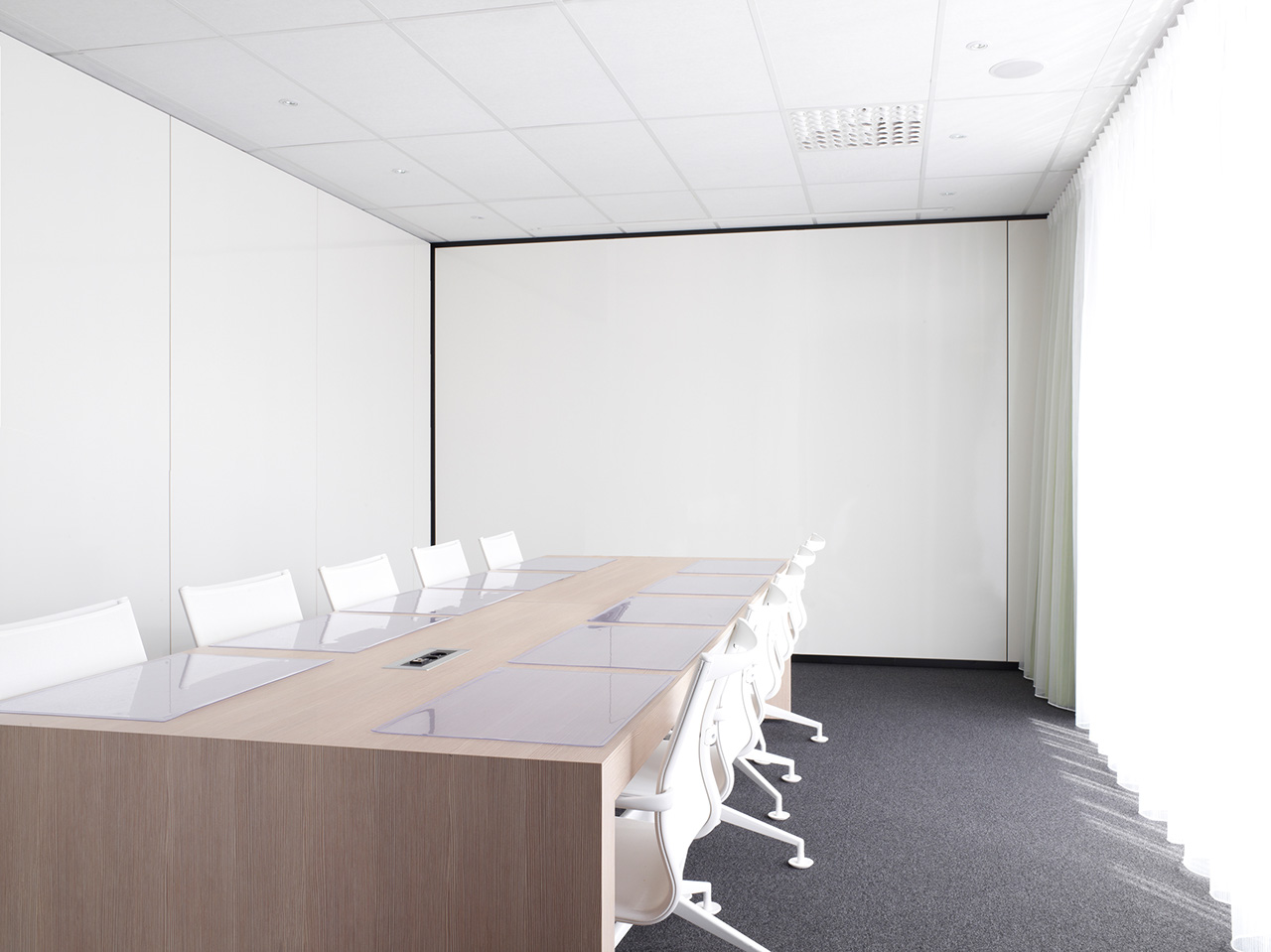 moderna sala za sastanke sa belim stolicama i drvenim konferencijskim stolom
